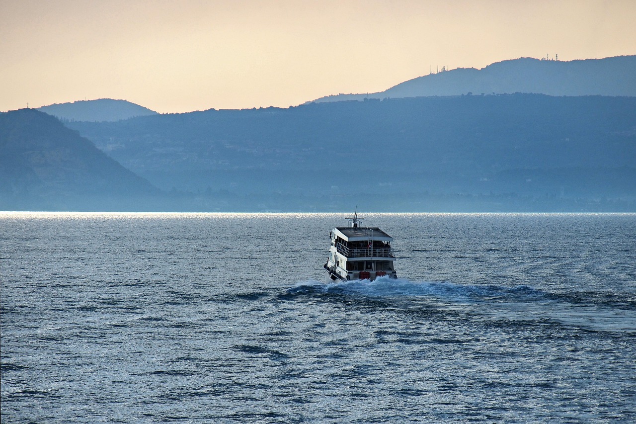 Passagierschiff auf dem Gardasee vor Bergsilhouetten im Dunst