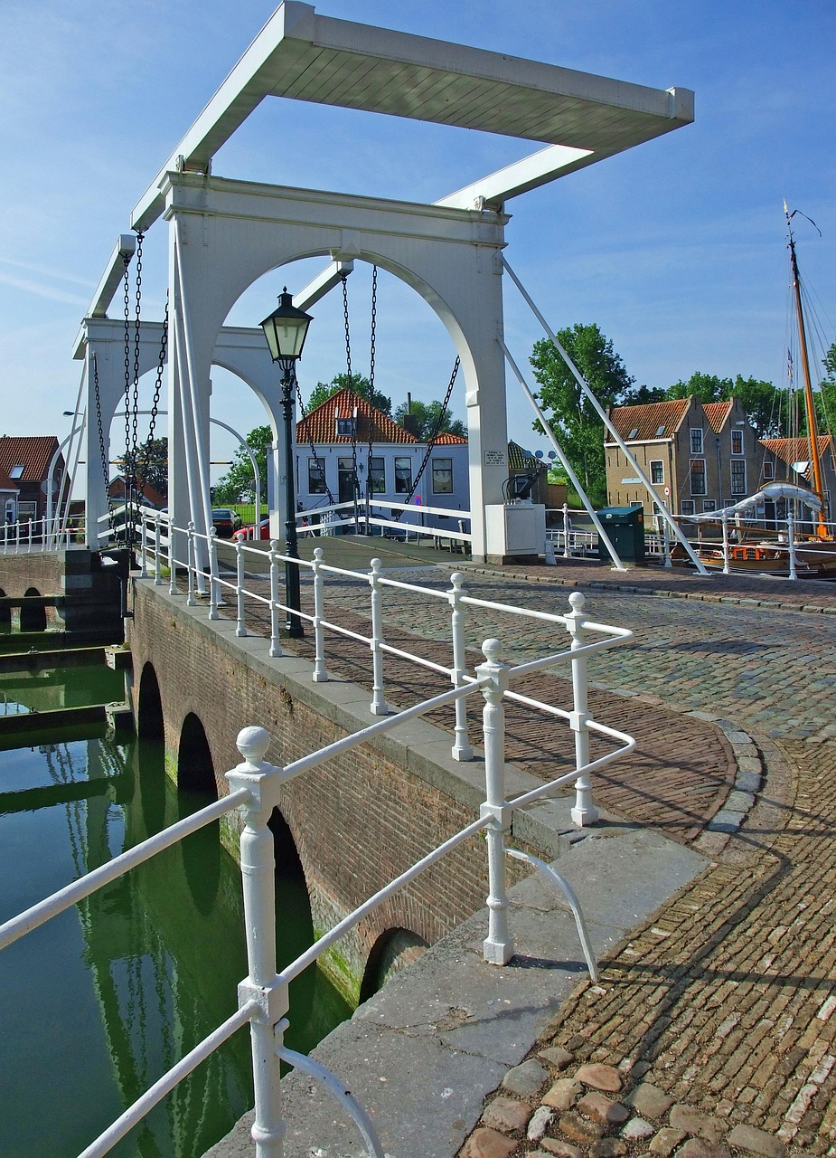 Weiße Zugbrücke über einen Kanal in Zierikzee mit Segelschiff und Backsteinhäusern